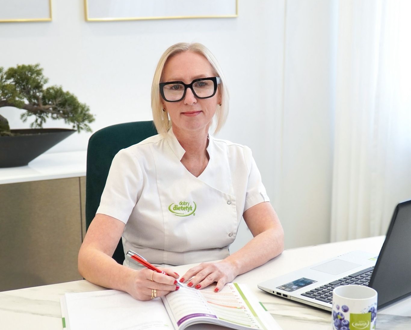 Dietetyczka Dorota Żmijan przy biurku w gabinecie